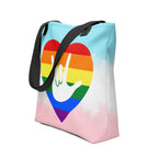 An angled view of a white Tote bag with a black handle and a pride heart with the ASL I love you sign at its center.