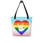 Tote bag with a black handle and a pride heart with the ASL I love you sign at its center.