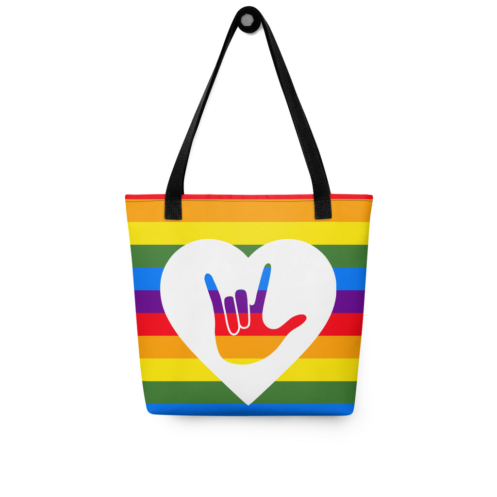 Pride rainbow coloured tote bag with a black handle and a white heart with the ASL I love you sign at its centre.