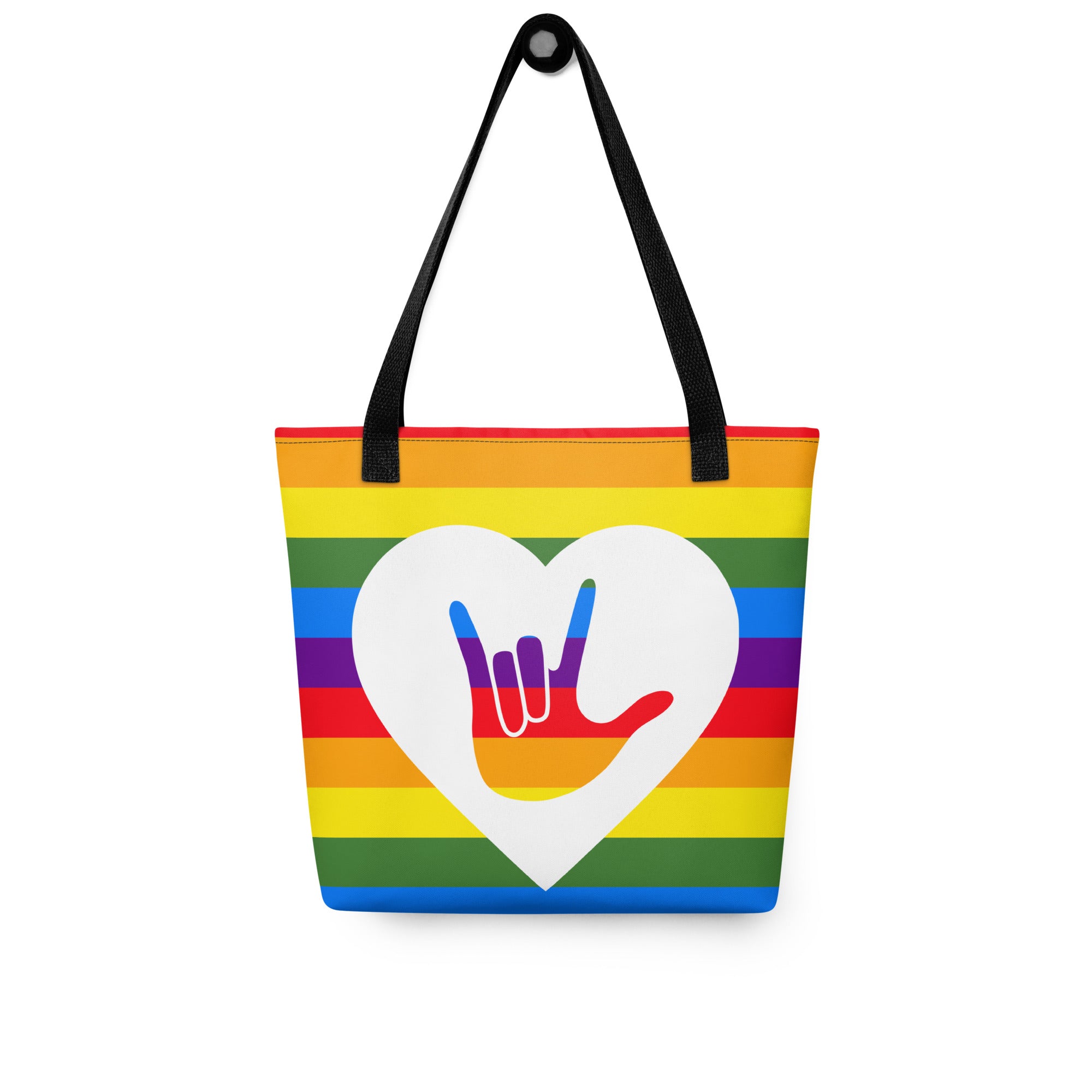 Pride rainbow coloured tote bag with a black handle and a white heart with the ASL I love you sign at its centre.