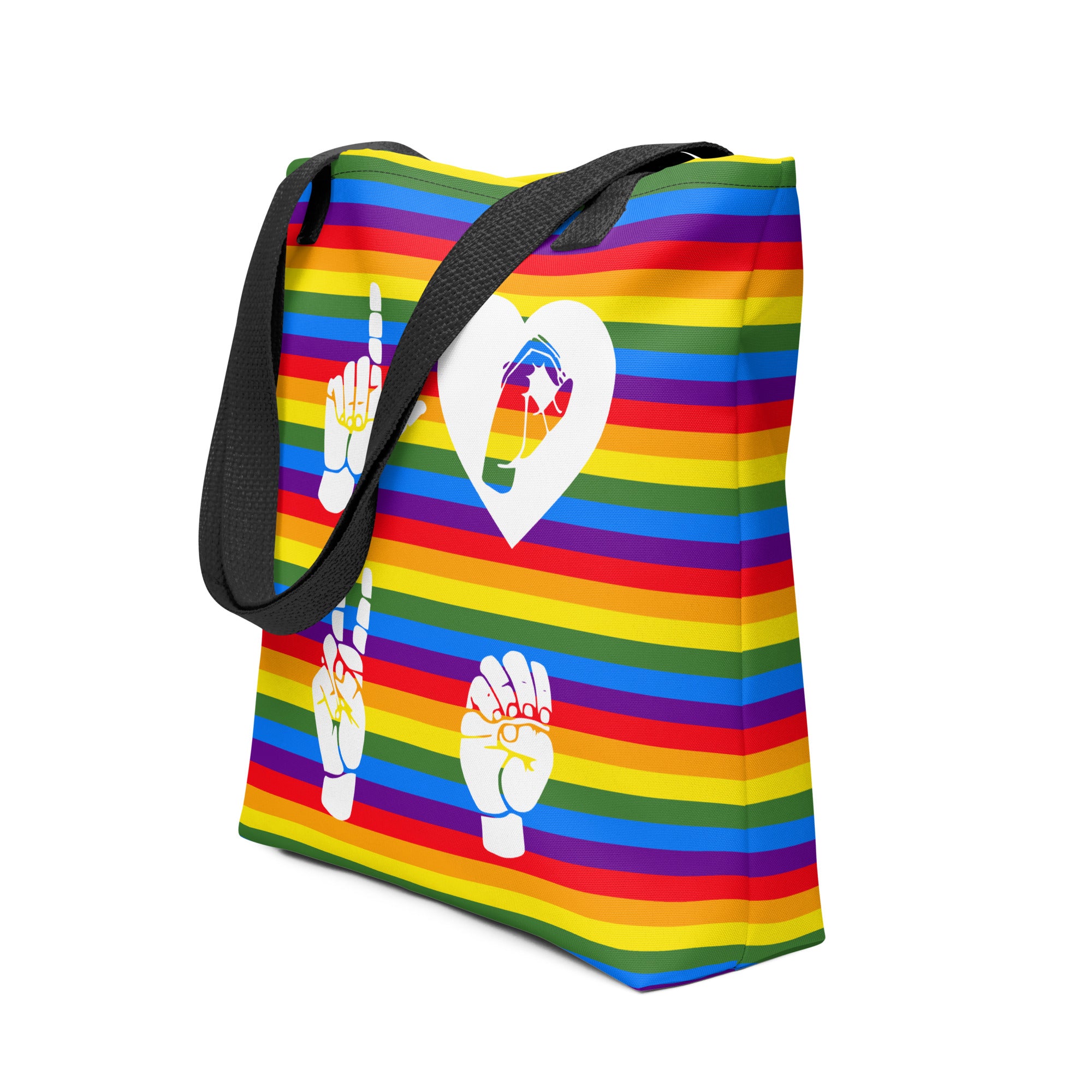 An angled view of a pride rainbow colored tote bag with a black handle and the word LOVE in white ASL fingerspelling design