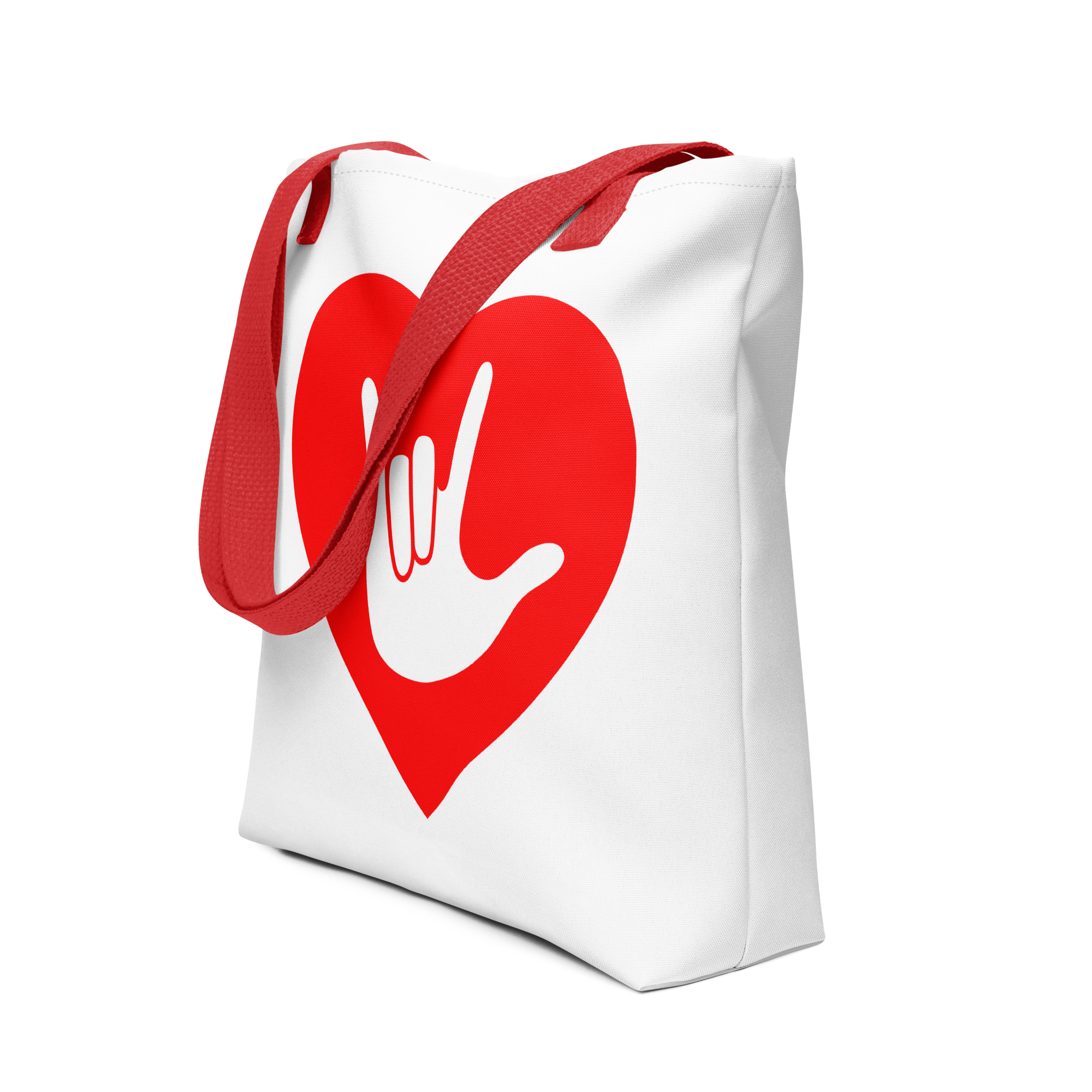 An angled view of a white Tote bag with a red handle and a red heart with the ASL I love you sign at its center.