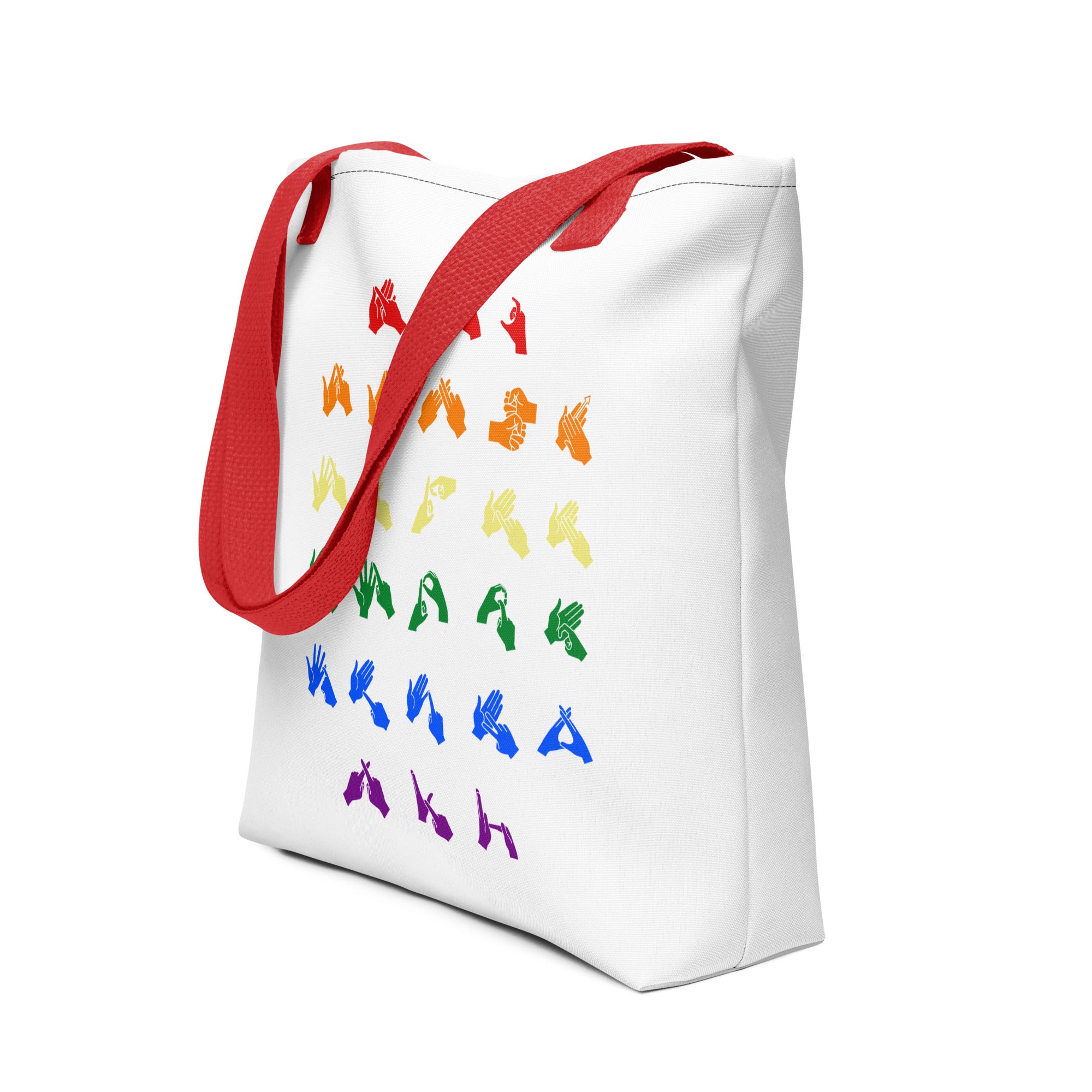 An angled view of a white Tote Bag with red handles showing the BSL Alphabet - Pride Fingerspelling