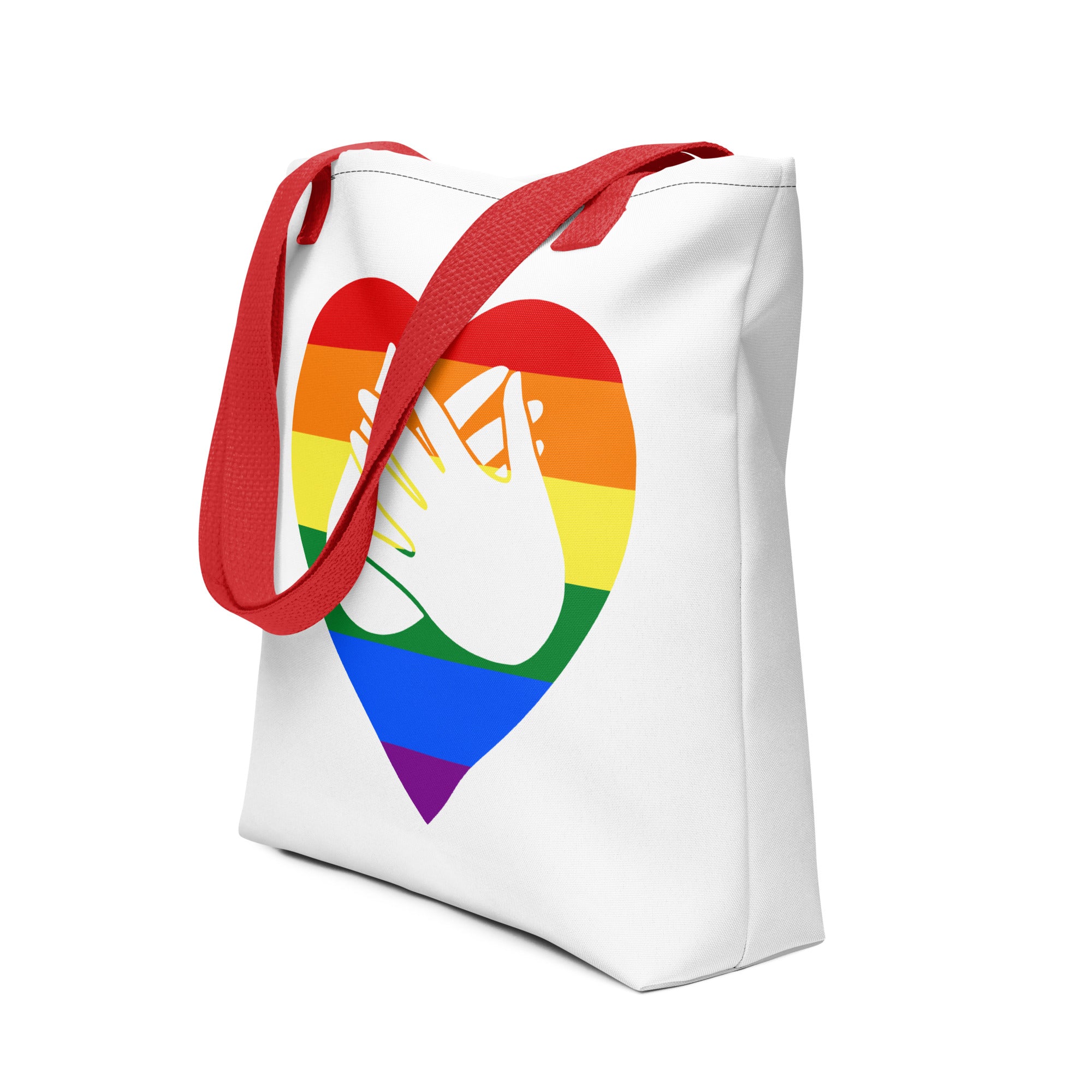 An angled view of a white Tote bag with a red handle and a pride heart with the BSL love sign at its centre.