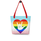Tote bag with a red handle and a pride heart with the ASL I love you sign at its center.