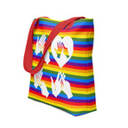 An angled view of a pride rainbow coloured tote bag with a red handle and the word LOVE in white BSL fingerspelling design