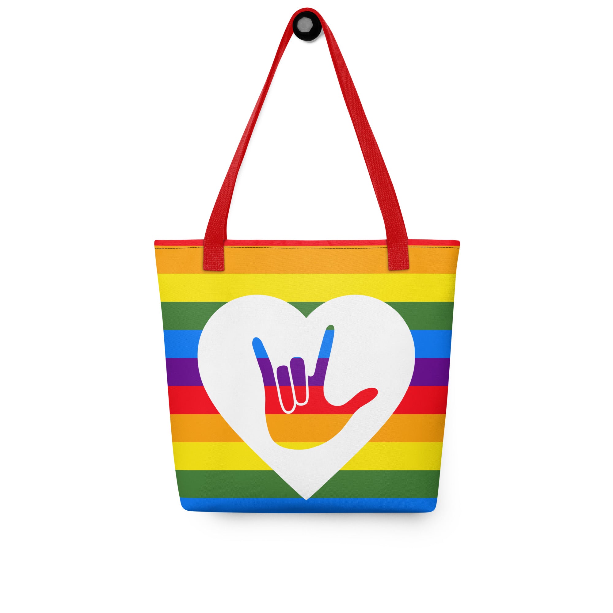 Pride rainbow coloured tote bag with a red handle and a white heart with the ASL I love you sign at its centre.