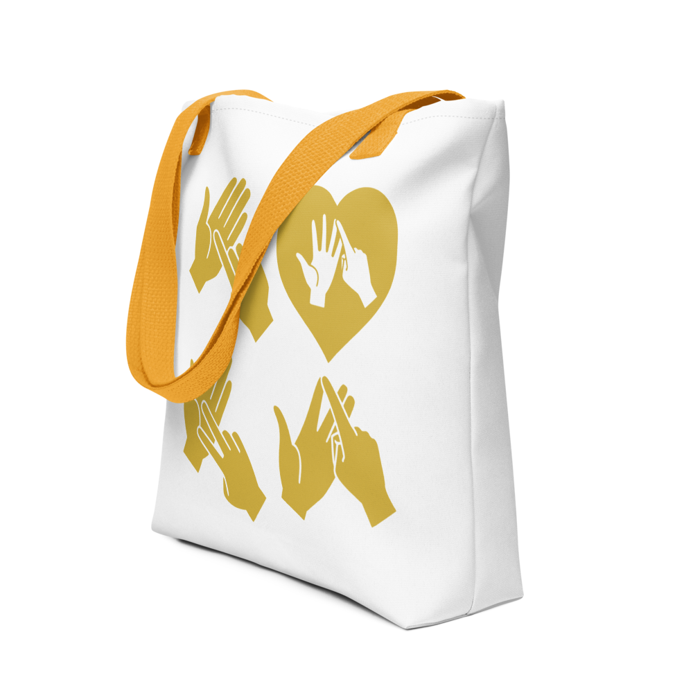 An angled view of a white Tote Bag with yellow handle showing the word Love in gold BSL Fingerspelling with the 'O' embedded in a heart shape