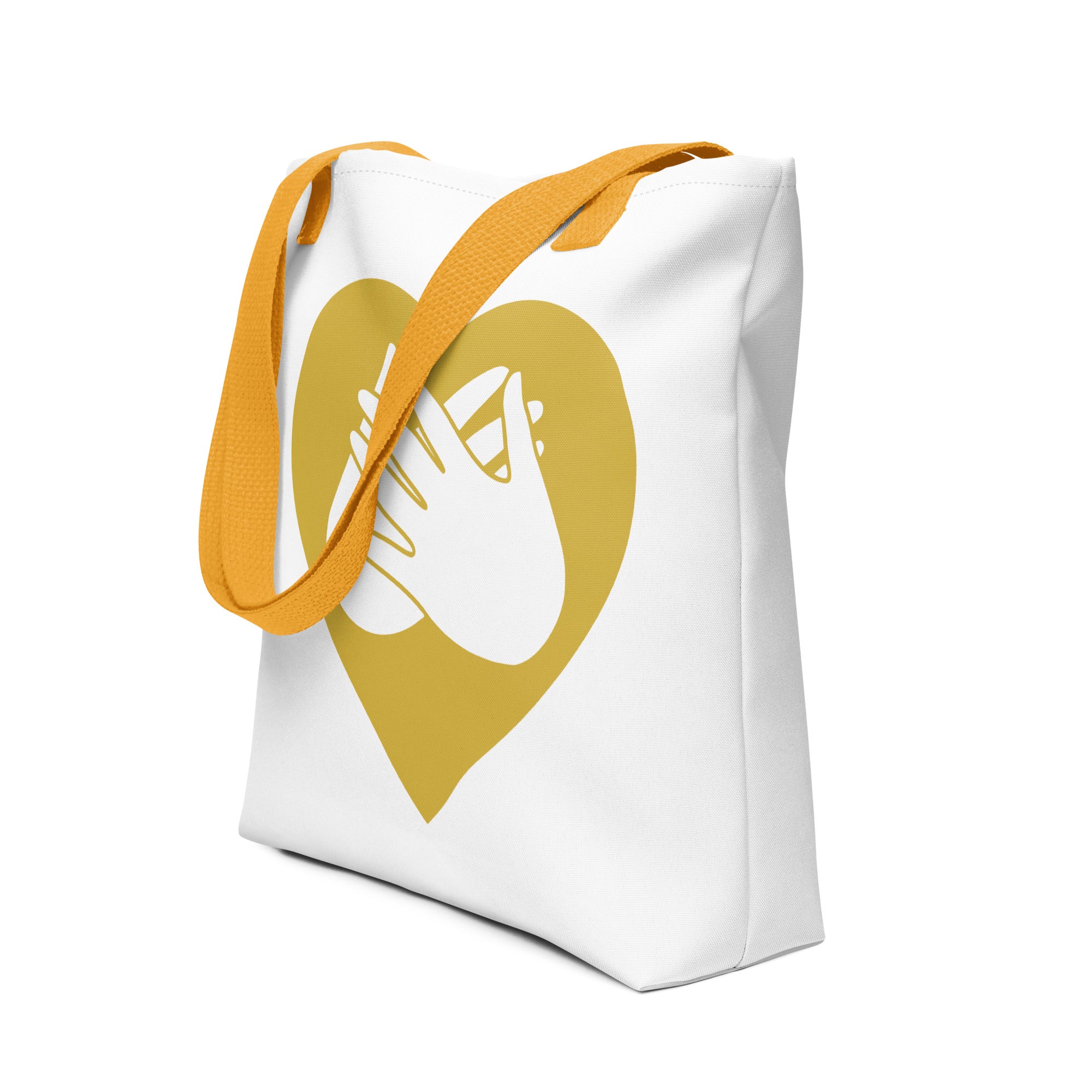 An angled view of a white Tote bag with a yellow handle and a gold heart with the BSL love sign at its centre.
