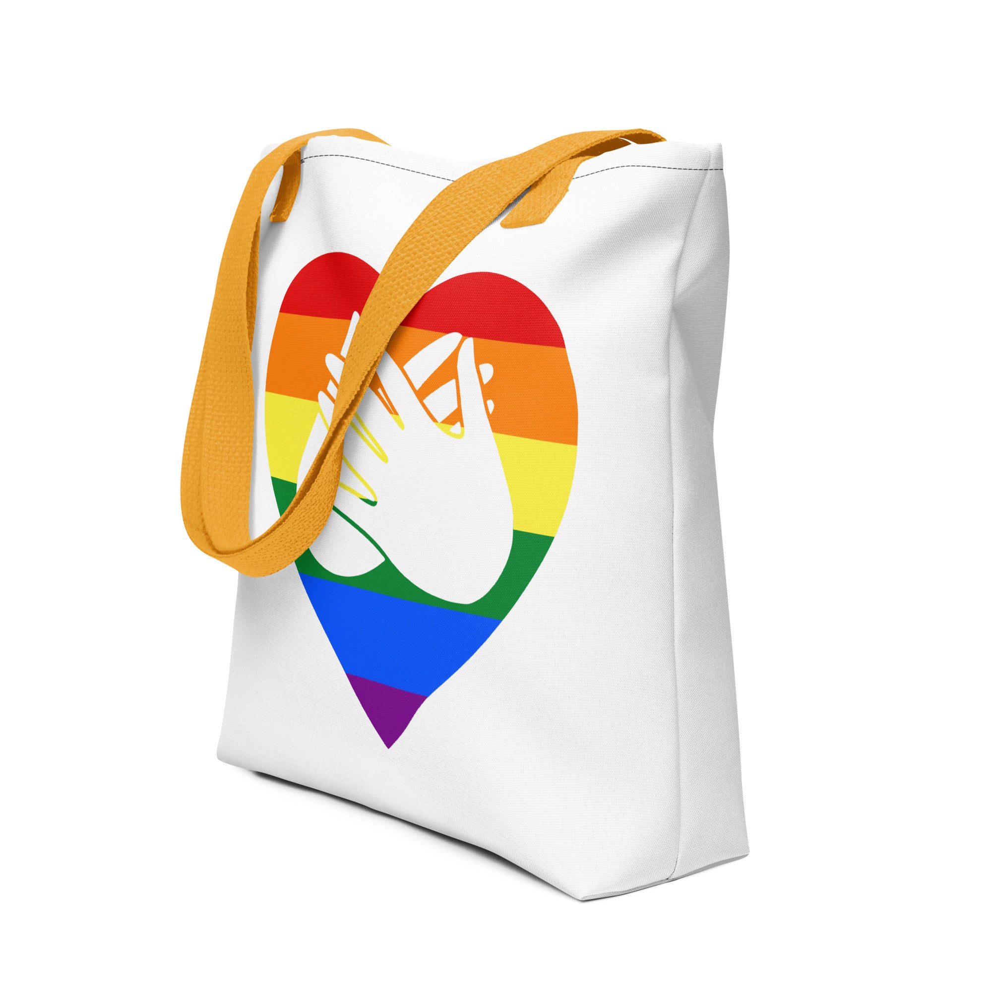An angled view of a white Tote bag with a yellow handle and a pride heart with the BSL love sign at its centre.