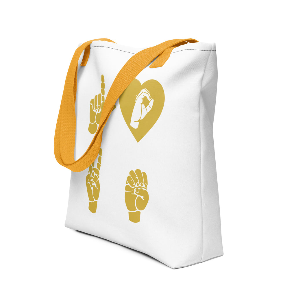 An angled view of a white Tote Bag with yellow handle showing the word Love in gold ASL Fingerspelling with the 'O' embedded in a heart shape