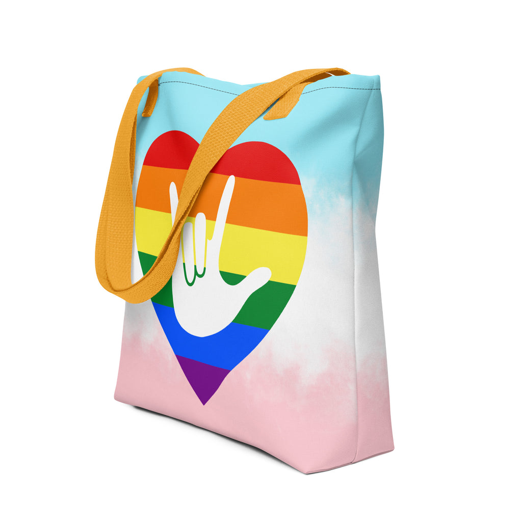 An angled view of a white Tote bag with a yellow handle and a pride heart with the ASL I love you sign at its center.