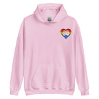 Front view of a light pink hoodie showing a pride coloured heart and the iconic BSL Love sign embedded in it on the left side of the chest