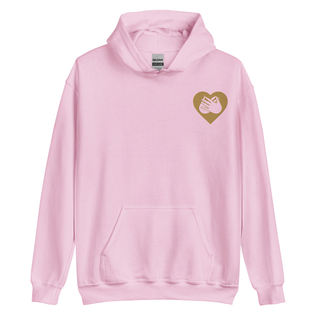 Front view of a light pink hoodie showing a gold coloured heart and the iconic BSL Love sign embedded in it on the left side of the chest