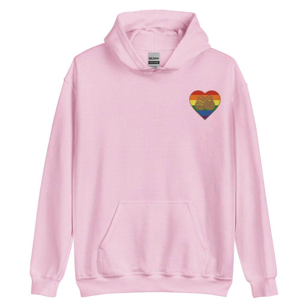 Front view of a light pink hoodie showing a pride coloured heart and the iconic BSL Love sign embedded in it on the left side of the chest