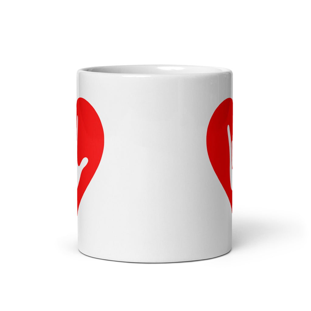 White mug with no handle visible, showing part of the red coloured heart design on each side.