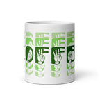 White mug with no handle visible, showing part of the phrase Coffee written in ASL Fingerspelling and Text wrapping around the mug in green cutaway design.