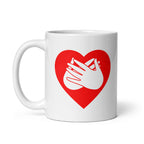 White mug with a red coloured heart design featuring the BSL sign for Love embedded in it. The mug handle is on the left hand side of the mug.