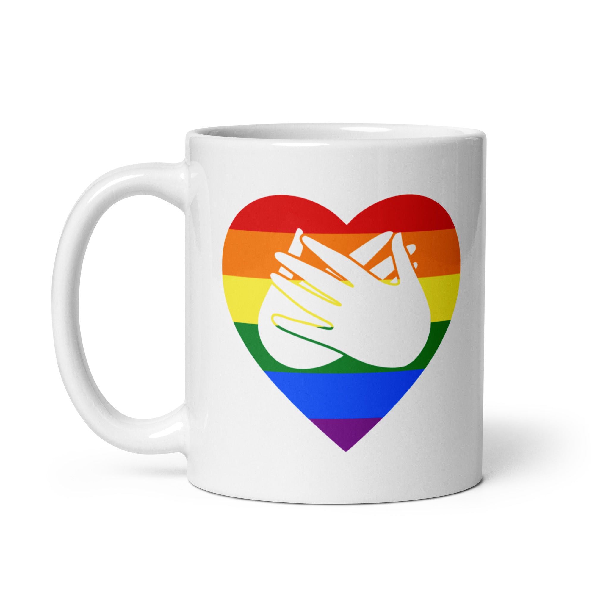 White mug with a pride coloured heart design featuring the BSL sign for Love embedded in it. The mug handle is on the left hand side of the mug.