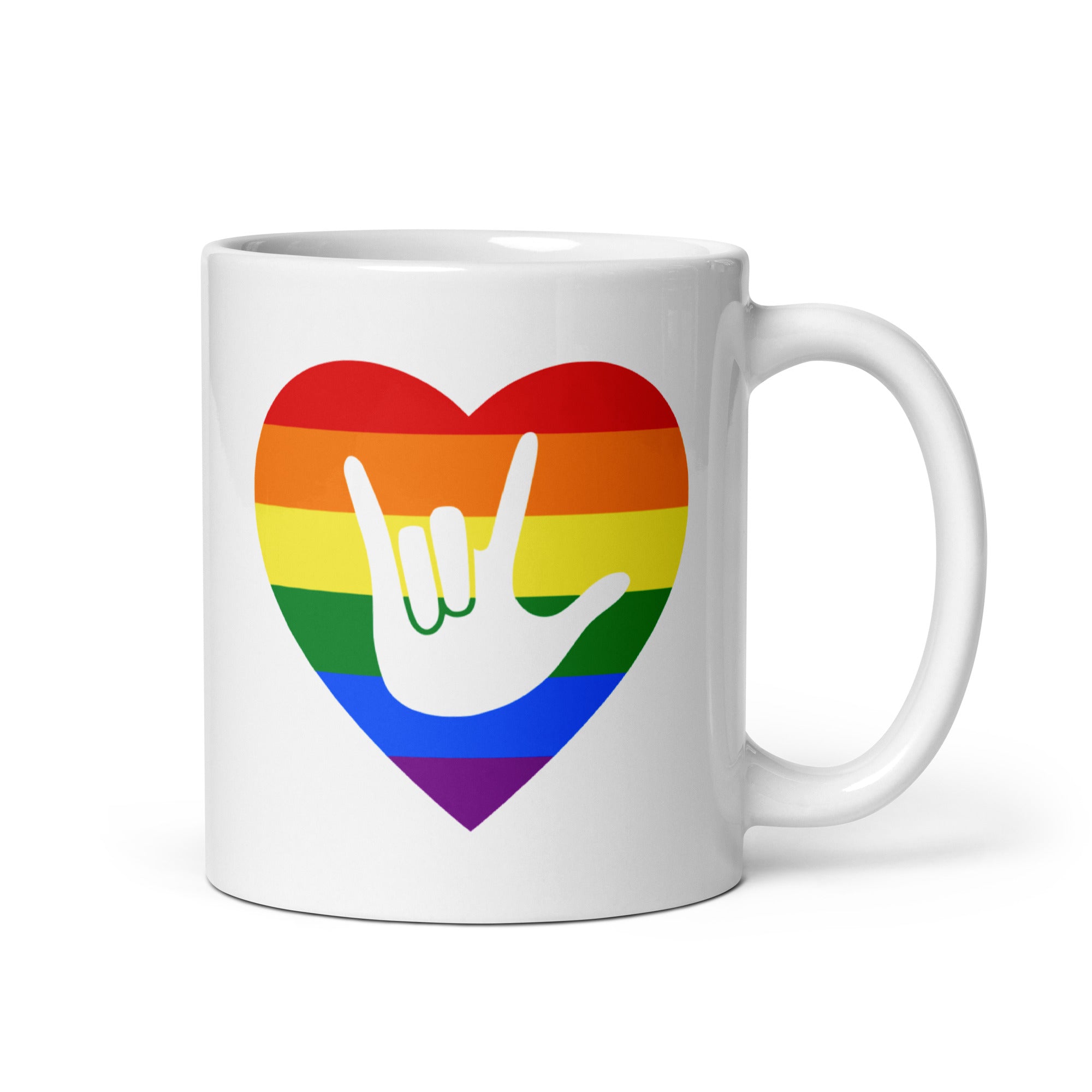 White mug with a rainbow heart design featuring the ASL sign for I Love You embedded in it. The mug handle is on the right hand side of the mug.