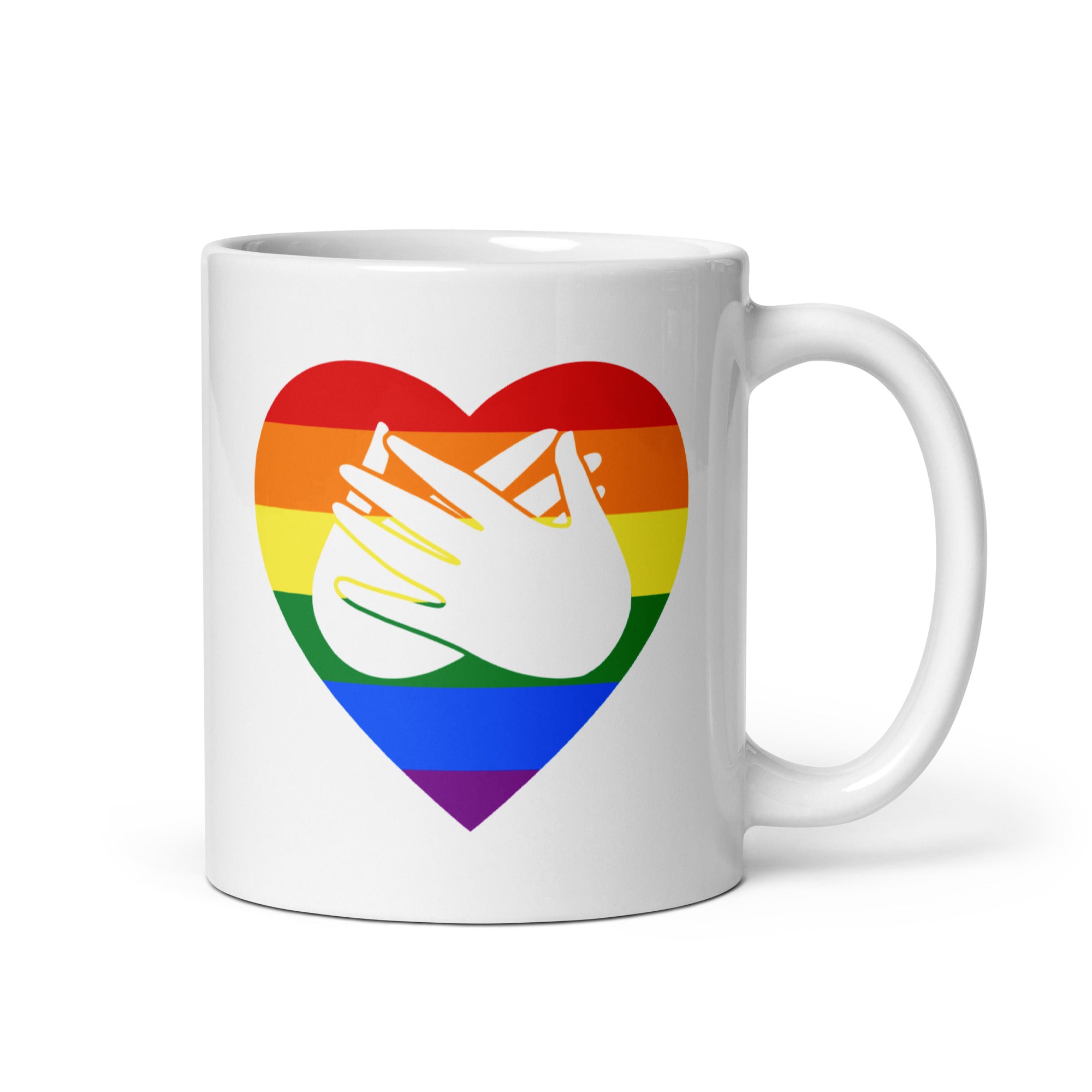 White mug with a pride coloured heart design featuring the BSL sign for Love embedded in it. The mug handle is on the right hand side of the mug.